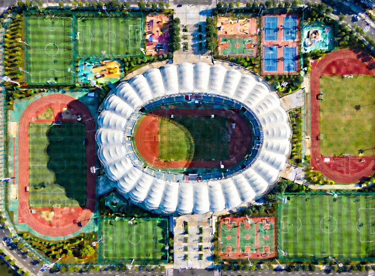 俯视角度拍摄的体育场馆与外围训练场地全景